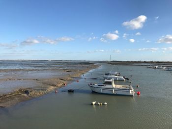 Boats moored on sea against sky