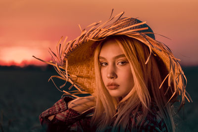 Portrait of woman wearing hat outdoors during sunset