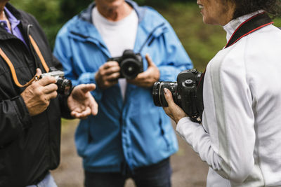 Female instructor explaining senior men during photography course