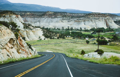 Road by landscape against sky