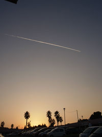 Silhouette palm trees against clear sky at sunset