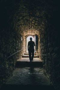 Rear view of man standing in tunnel