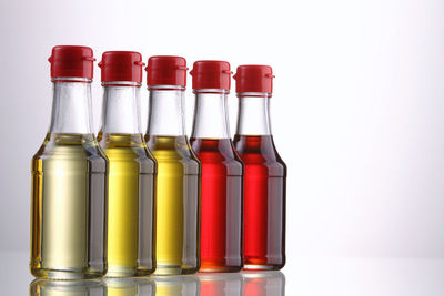 Close-up of cooking oil in bottles against white background