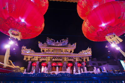 Low angle view of illuminated lanterns hanging in building at night