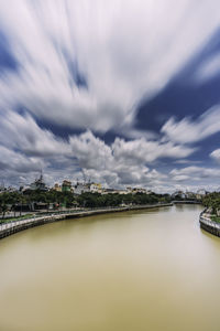 Bridge over river against cloudy sky