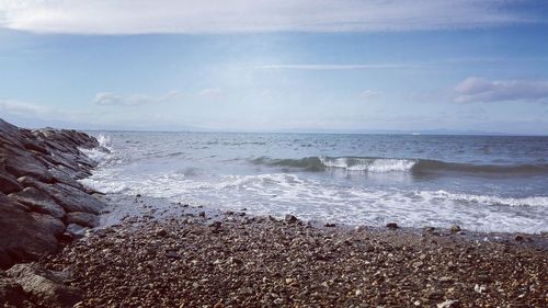 View of calm beach against blue sky