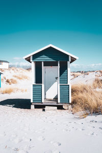 Wooden hut at skanör beach against clear blue sky.