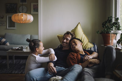 Daughter talking to gay parents sitting at home