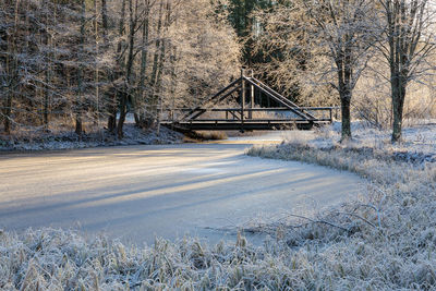 A footbridge across a frozen pond in frosty winter landscape in oulu, northern finland.