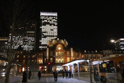 People walking in modern building at night