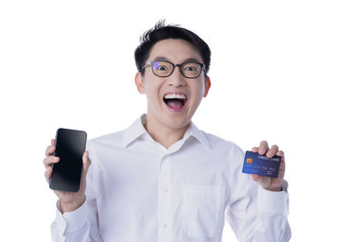 Portrait of mid adult man using smart phone against white background