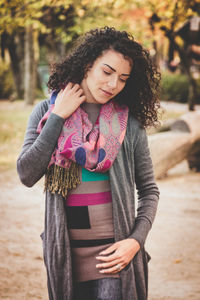 Young woman standing against tree