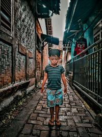 Full length of boy standing against graffiti