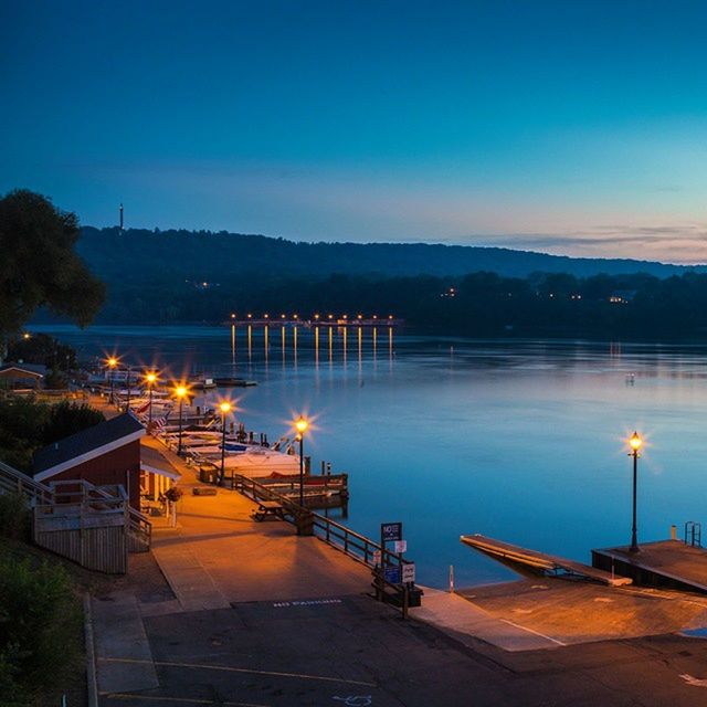 illuminated, night, built structure, building exterior, architecture, clear sky, blue, sky, street light, copy space, dusk, transportation, mountain, outdoors, lighting equipment, river, house, water, no people, tree