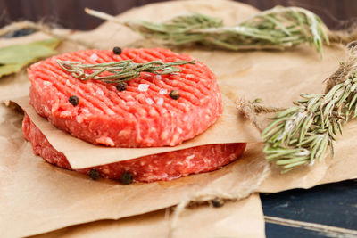 Raw hamburger patties with rosemary