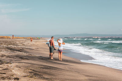 People at beach against sky