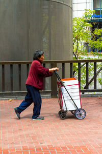 Side view of man walking on footpath