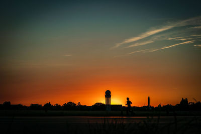 Scenic view of silhouette field against sky during sunset