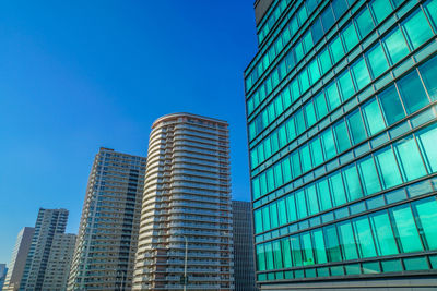 Low angle view of modern buildings against clear blue sky