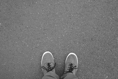 Low section of person standing on road