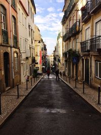 Man and woman walking on street amidst buildings