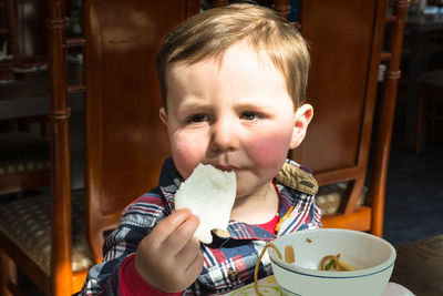 Close-up of boy eating food at table