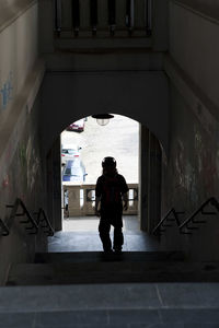 Rear view of silhouette man standing at entrance of building