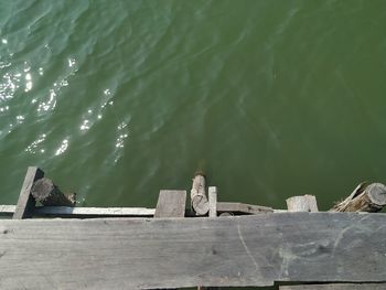 High angle view of people sitting on pier over lake