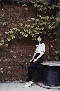 Portrait of woman standing against plants