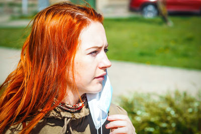Close-up portrait of young woman looking away outdoors