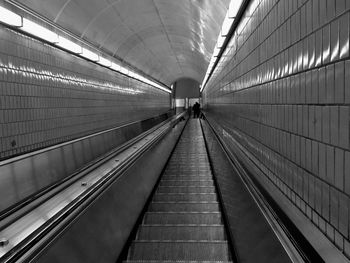 Rear view of woman on escalator