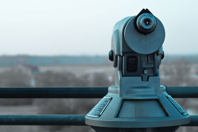 Close-up of coin-operated binocular against sky