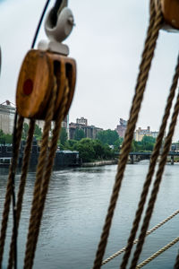 Close-up of rope hanging over river against sky