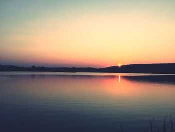 Scenic view of lake against romantic sky at sunset