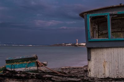 Abandoned built structure by sea against sky