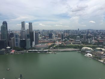 Aerial view of river amidst buildings in city against sky