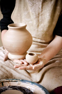 Sculpt man potter holds palms just made pitchers of different sizes. potter holds made pots.   