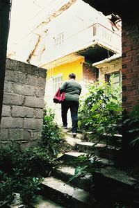 Rear view of man standing by building