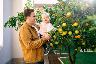 Portrait of boy holding fruits at home