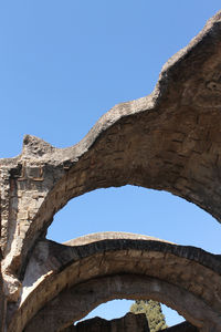 Low angle view of old ruin building against blue sky