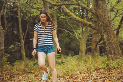 Young woman standing in forest