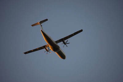 Low angle view of airplane flying against clear sky