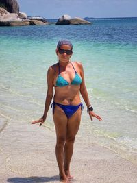 Full length of young woman in bikini standing on beach