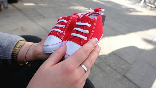 Woman holding pair of shoes