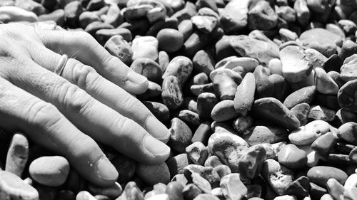 Close-up of hand touching stones