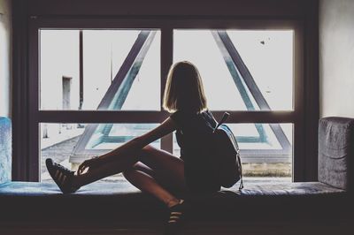 Woman sitting by window at home