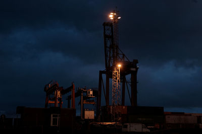 Low angle view of illuminated city against sky at night