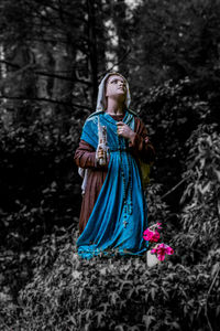 Midsection of woman standing by tree in forest