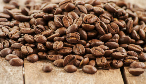 Close-up of roasted coffee beans on wooden table