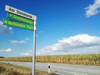 Road leading towards sea against cloudy sky